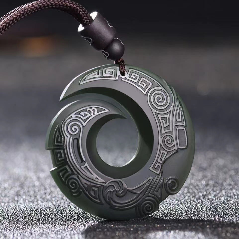 Close up of fine hand carved details on a natural nephrite jade pendant
