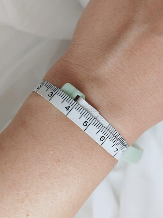 bracelet size chart showing how to measure wrist for a bracelet with a flexible measuring tape