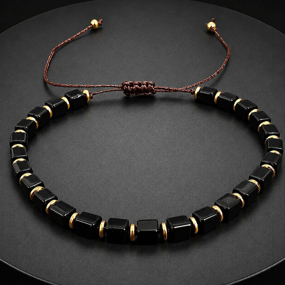 Adjustable black obsidian bracelet with gold accent beads close up