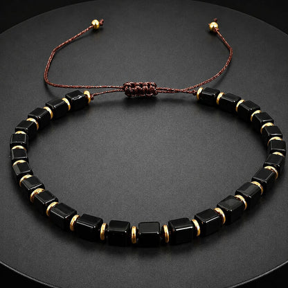 Adjustable black obsidian bracelet with gold accent beads close up