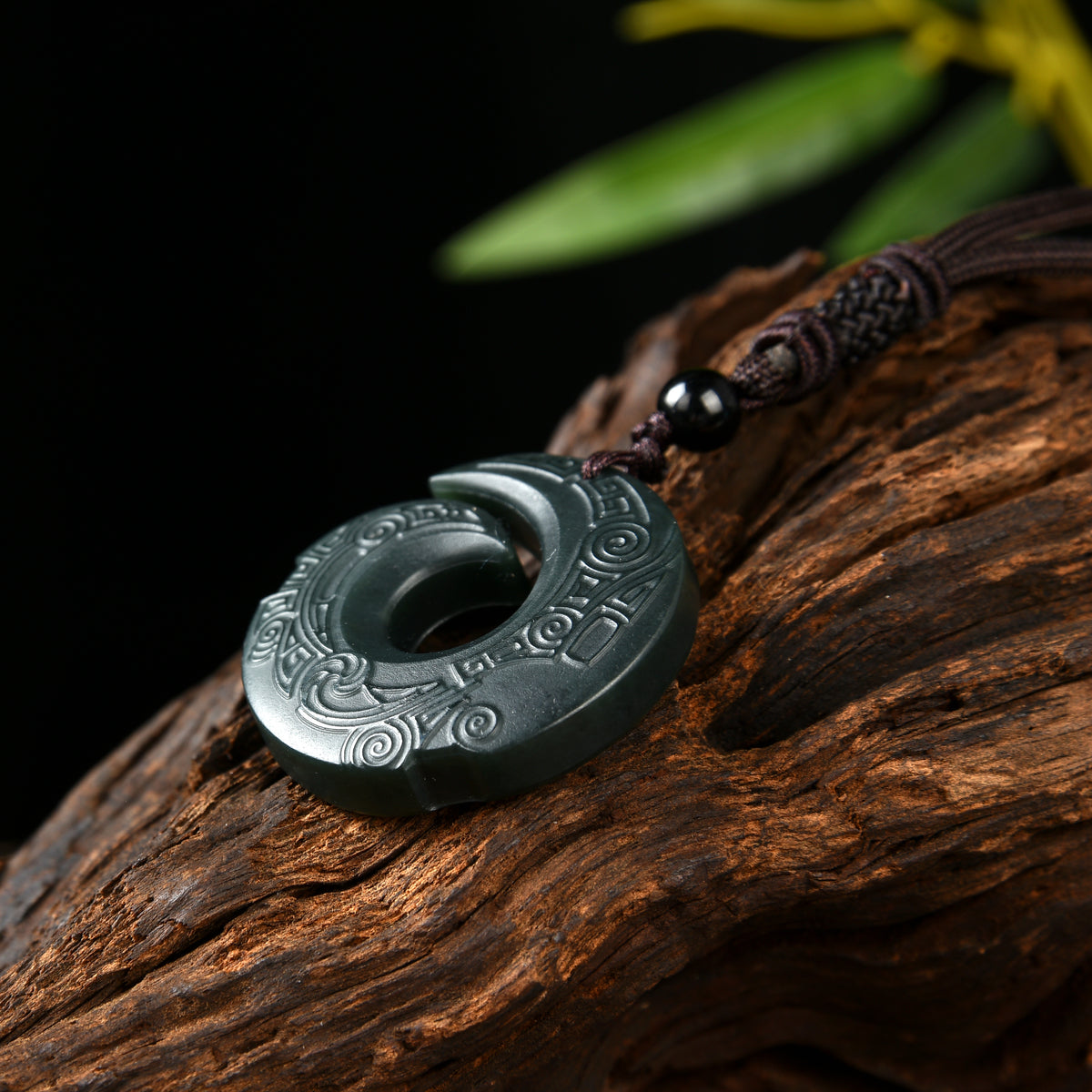 Side view showing the carving and polished surface of a Hetian nephrite jade pendant