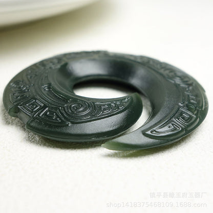 Close up of fine hand carved details on a natural nephrite jade pendant